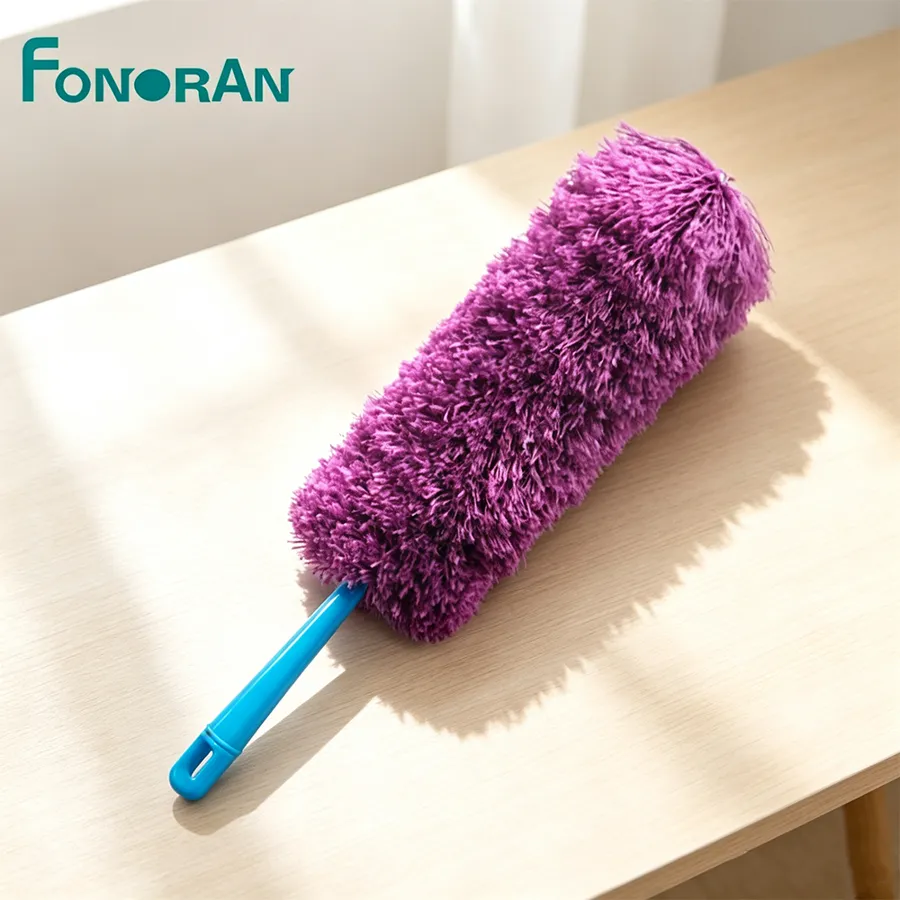 Close-up of a purple chenille microfiber duster head with a blue handle resting on a wooden table