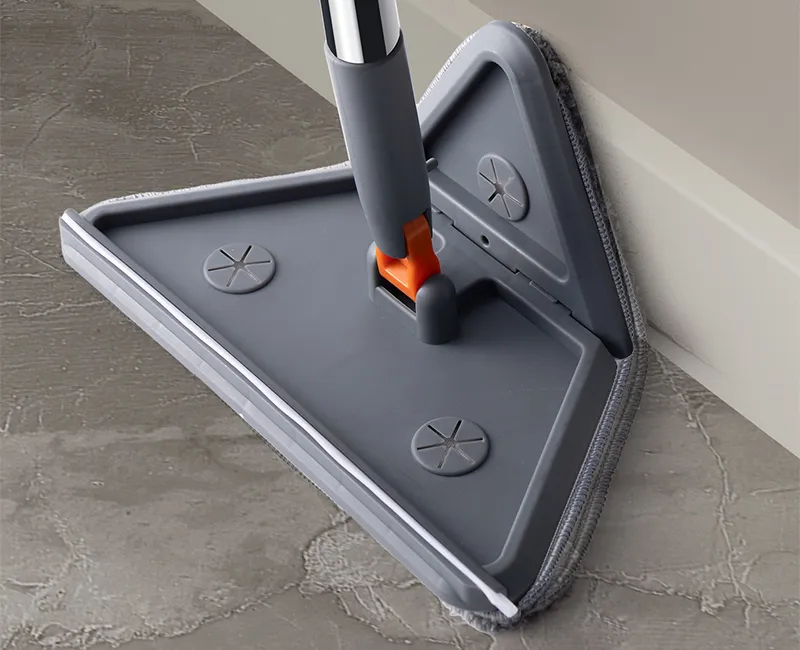 Grey folding triangle mop head pushed into a floor corner along the baseboard