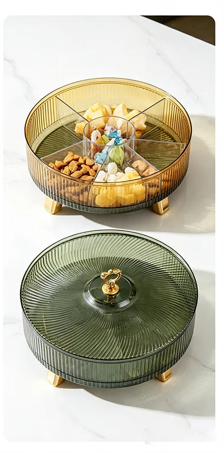 Two round tinted rotating storage containers with gold feet holding snacks