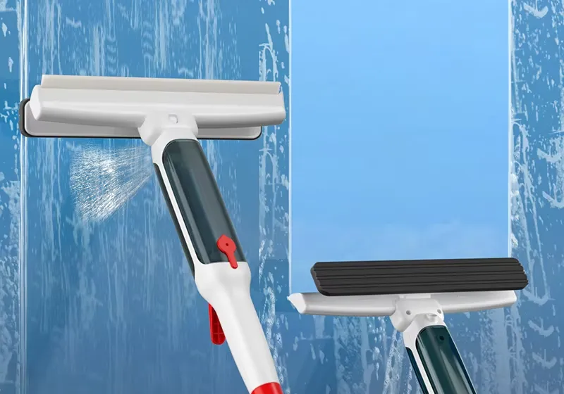 Spray window squeegee misting wet glass next to a second squeegee with a black rubber blade